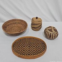 Set of four woven baskets and tray shown from above on white background.