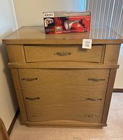 Photo of solid wood dresser with four drawers and Homedics massager box on top.