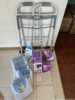 Overview photo showing the aluminum walker behind a basket containing compression stockings, gloves and six packages of Jockey tank tops arranged on the floor.