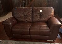 Front view of brown loveseat showing seat cushions, back cushions and arms