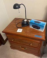 Nightstand with the lamp and radio on top, showing size and condition.