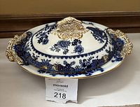 Vintage blue and gold Ashwood covered serving dish with ornate gold handles and lid handle, displayed closed from top angle.