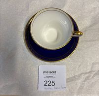 Top view of white interior teacup on royal blue and gold saucer