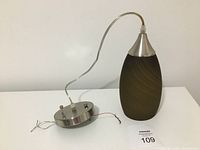 Glass pendant light with metal canopy and wiring shown assembled and detached.