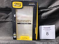 Photo of empty OtterBox Symmetry Series packaging box for iPhone XS Max, yellow and black colors, front side showing model fitment