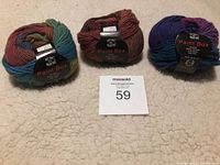Three balls of Knit One Crochet Too Paint Box 100% wool yarn in different colorways on carpet background with auction lot number visible.