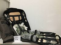 Backpack opened showing contents inside, including utensils and plates secured with straps.