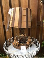 Full view of the carved wood lamp with wooden panel lampshade, showing size and overall design