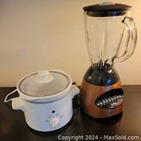 Side-by-side view of Vitantonio copper 6-speed blender and Essential Needs small slow cooker on black surface.