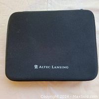 Closed black zippered carrying case with Altec Lansing logo on top.