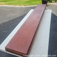 Top and face view of the solid wood slab mantle, showing reddish-brown wood grain and built-up trim base.