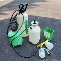 Photo showing 3 pump sprayers with hoses, 2 smaller hose-end sprayers, and 1 green manual handheld grass seeder