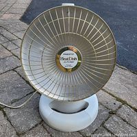 Front view of the Presto HeatDish radiant heater showing its round metal grille and central logo.