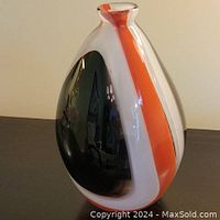 Front view of blown glass vase showing red, white, and black swirled design and shape