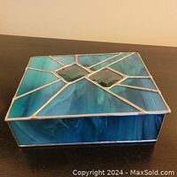Top and sides of small turquoise stained glass trinket box showing geometric pattern and diamond-shaped accents.