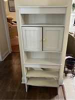 Entire white wooden cabinet capturing its structure, shelves, and doors