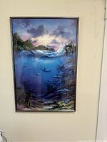 Front view of framed large wall art showing vibrant ocean and underwater scene with waves, fish, and islands.