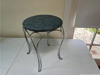 Photo of the makeup vanity stool showing metal frame and blue patterned cushioned seat