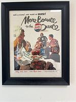 Photo of a framed vintage Pepsi advertisement print with retro cooking/picnic theme and black frame.