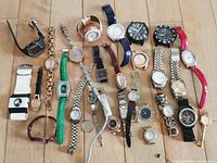 All 27 watches arranged on wood floor showing variety of bands, face shapes and colors