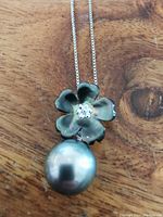 Close-up of the pearl pendant and sterling silver flower with rhinestones.