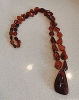 Full view of the amber necklace showcasing the overall length and bead shapes.
