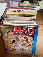Top view showing a box filled with multiple MAD magazine issues, featuring visible cover of issue No 285 March 1989 depicting wrestlers and caricature art