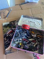 Overview photo showing Hello Kitty tin with motorcycle toy models inside and motorcycle magazine on side.