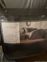 Front packaging photo of the Threshold Washed Cotton Sateen Comforter Set showing branding, product name, size, and bedding set image in black.