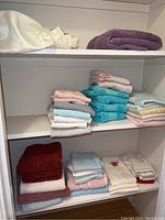 Shelving unit with a variety of folded hand and bath towels in multiple colors and patterns.