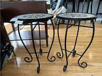 Two metal side tables with curved legs and scroll feet, showing the structure and overall appearance of tables