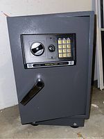 Front view of gray metal Bunker Hill digital floor safe showing keypad, key lock, and handle.