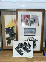 View of multiple framed and unframed art prints arranged together showing varied styles and sizes.