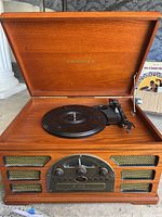 Open top showing vinyl record player turntable inside wood finish housing with Crosley logo inside lid.