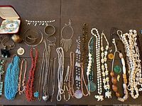 Full view of assorted jewelry lot including necklaces, bracelets, rings, and earrings made from turquoise, coral, silver, sea glass, and natural stones.