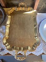 Full top view of gold plated footed serving tray showing etched patterns and scalloped rim.