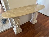 Full view of the two columns supporting the surfboard-shaped table top from an angle