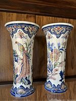 Paired vases showing distinct bird and floral designs from front view