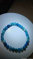 Top view of a natural blue agate bead stretchy bracelet laid flat, showing the color variations and bead shapes.