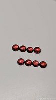 Nine round cabochon garnet stones in strong orange pink color, arranged in two rows, total weight 2.78ct