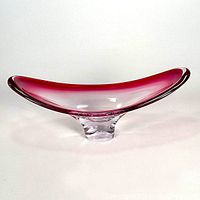 Front view of low slung clear to hot pink gradient glass console bowl showing its elongated curved shape and pedestal base.