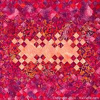 Close-up of the central section of the quilt showing finely pieced one-inch squares in jewel tones with a central pale yellow and peach daisy floral print pattern.