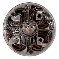 Front view of round art pottery charger with geometric sunburst and stylized human face design, multicolor glazed raised details.