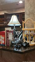 Wine accessories displayed on a kitchen countertop including a lamp, wine books, and metal wine tools
