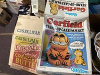 Original box for Wilton Garfield stand-up cake pan set with colorful graphics and text describing the 3D cake pan capability.