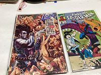 Six comic books in plastic sleeves: Crisis on Infinite Earths, and The Amazing Spider-Man Issue 251 with colorful cover art.