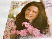 Front cover of Loretta Lynn's Greatest Hits Vol II showing portrait of Loretta Lynn holding pink flowers.