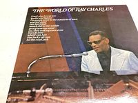 Album cover featuring Ray Charles playing piano in white jacket and sunglasses with title and song list visible.