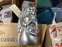 Aluminum Santa Claus shaped cake pan showing front detail of Santa with sack of toys.