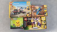 Four boxed LEGO sets including three LEGO Creator 3-in-1 sets and one LEGO BrickHeadz set.